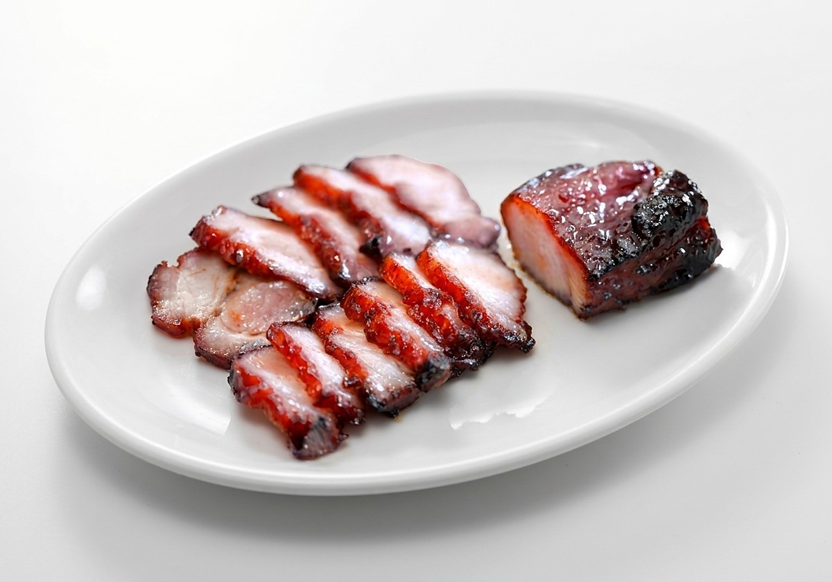 Sliced char siew plated with a whole glazed piece